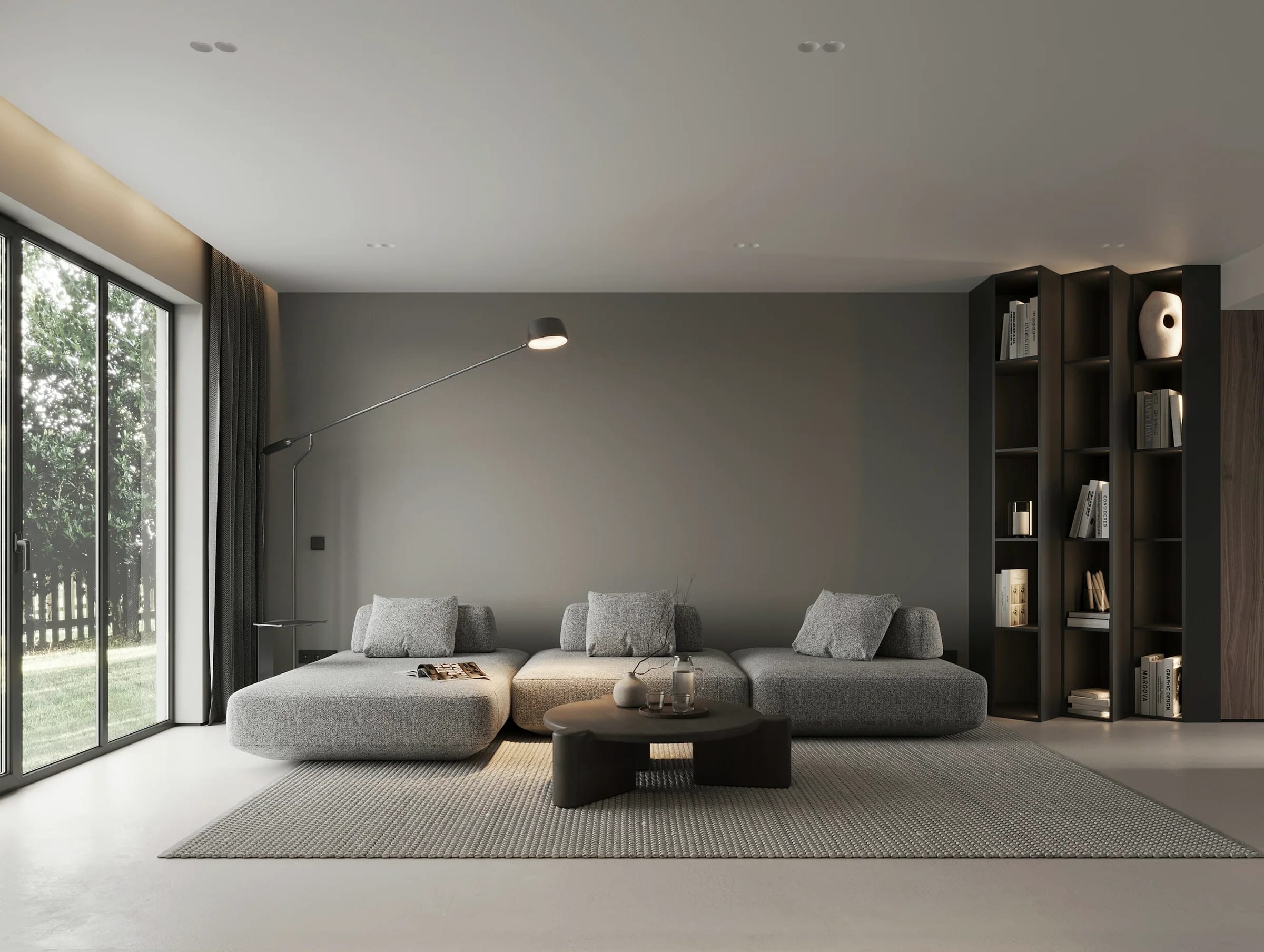 An open-plan room with low seating looking onto a garden