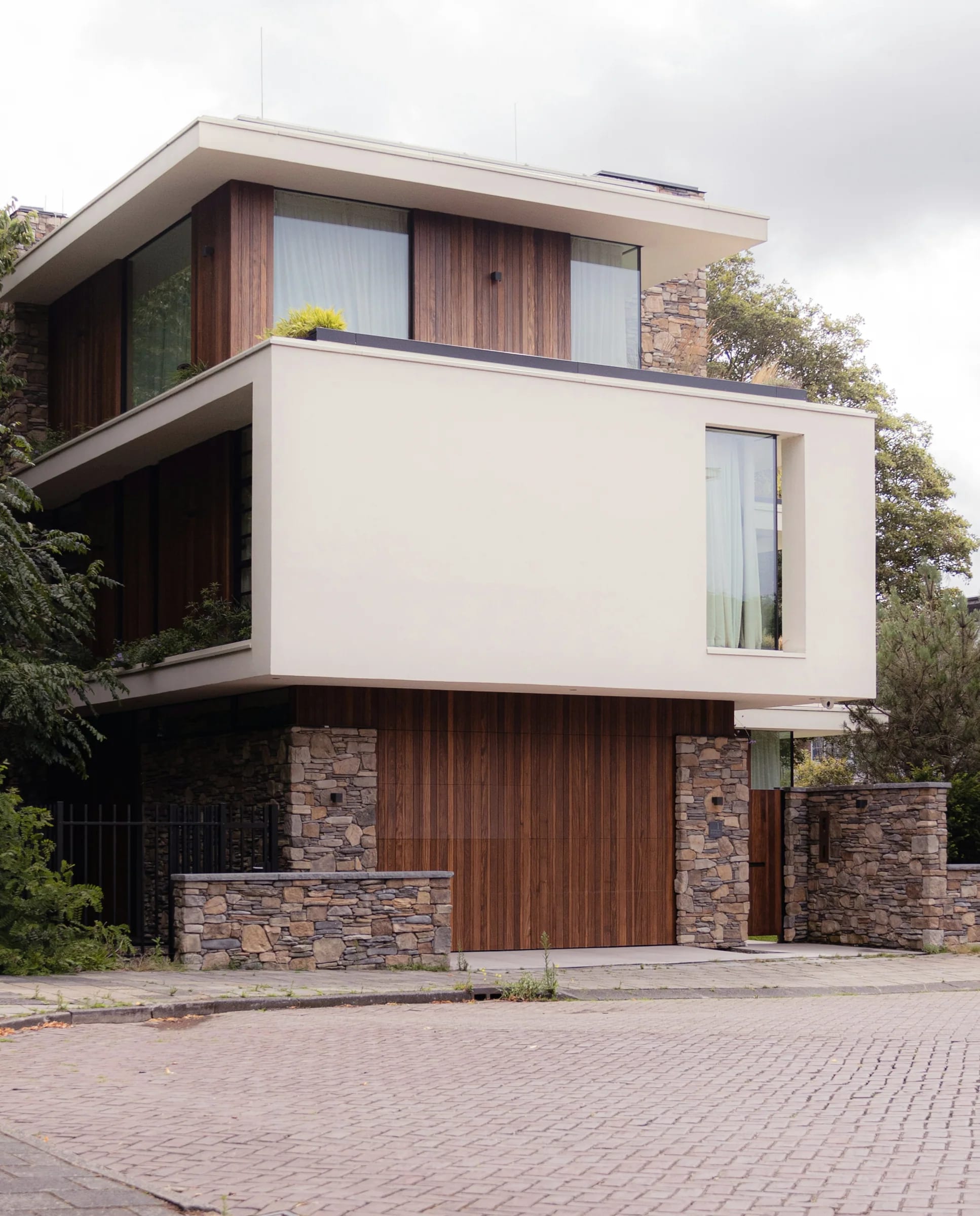 A cantilevered timber volume above a stone base