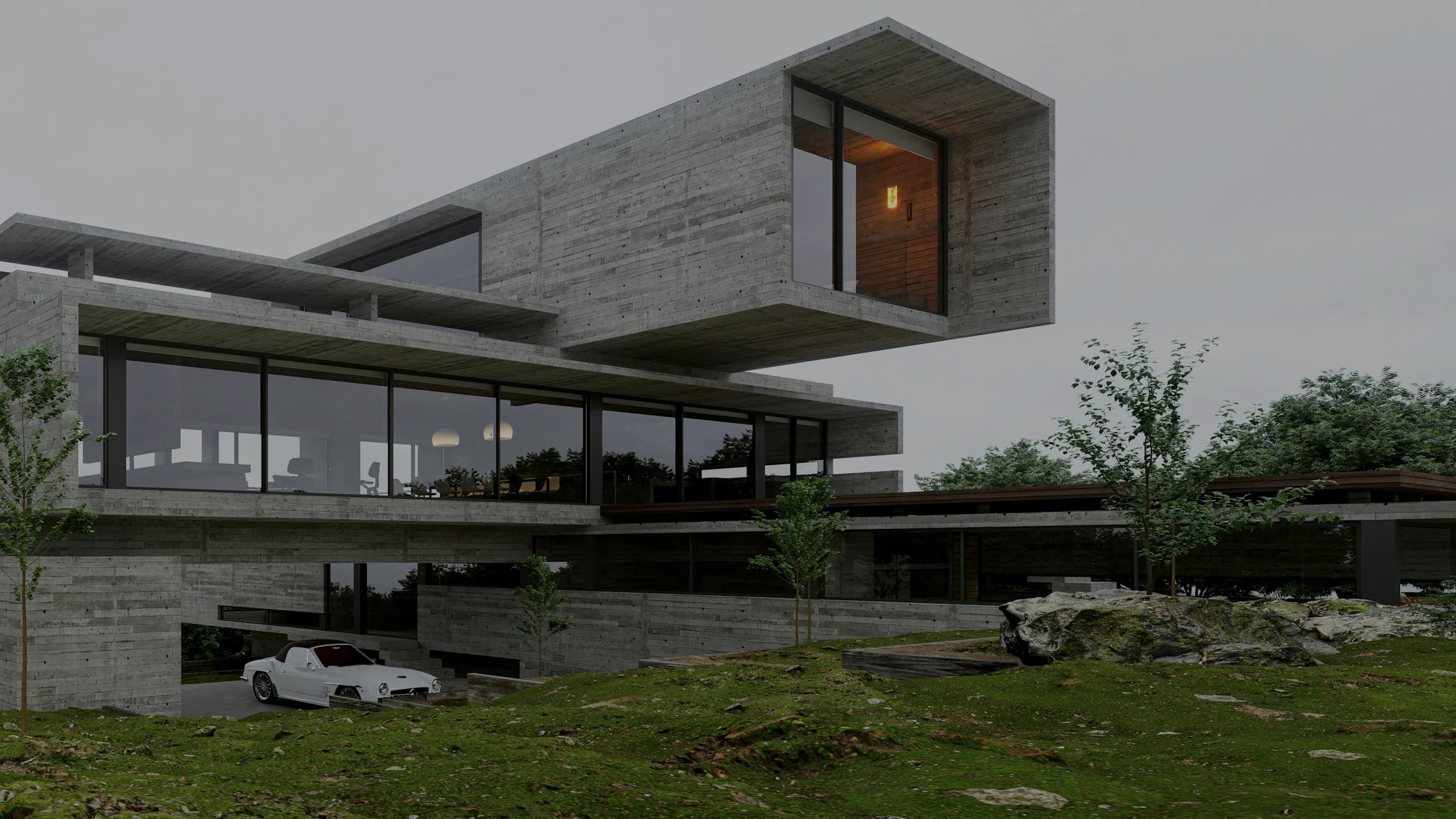 A long concrete house stepping down a grassed hillside at dusk