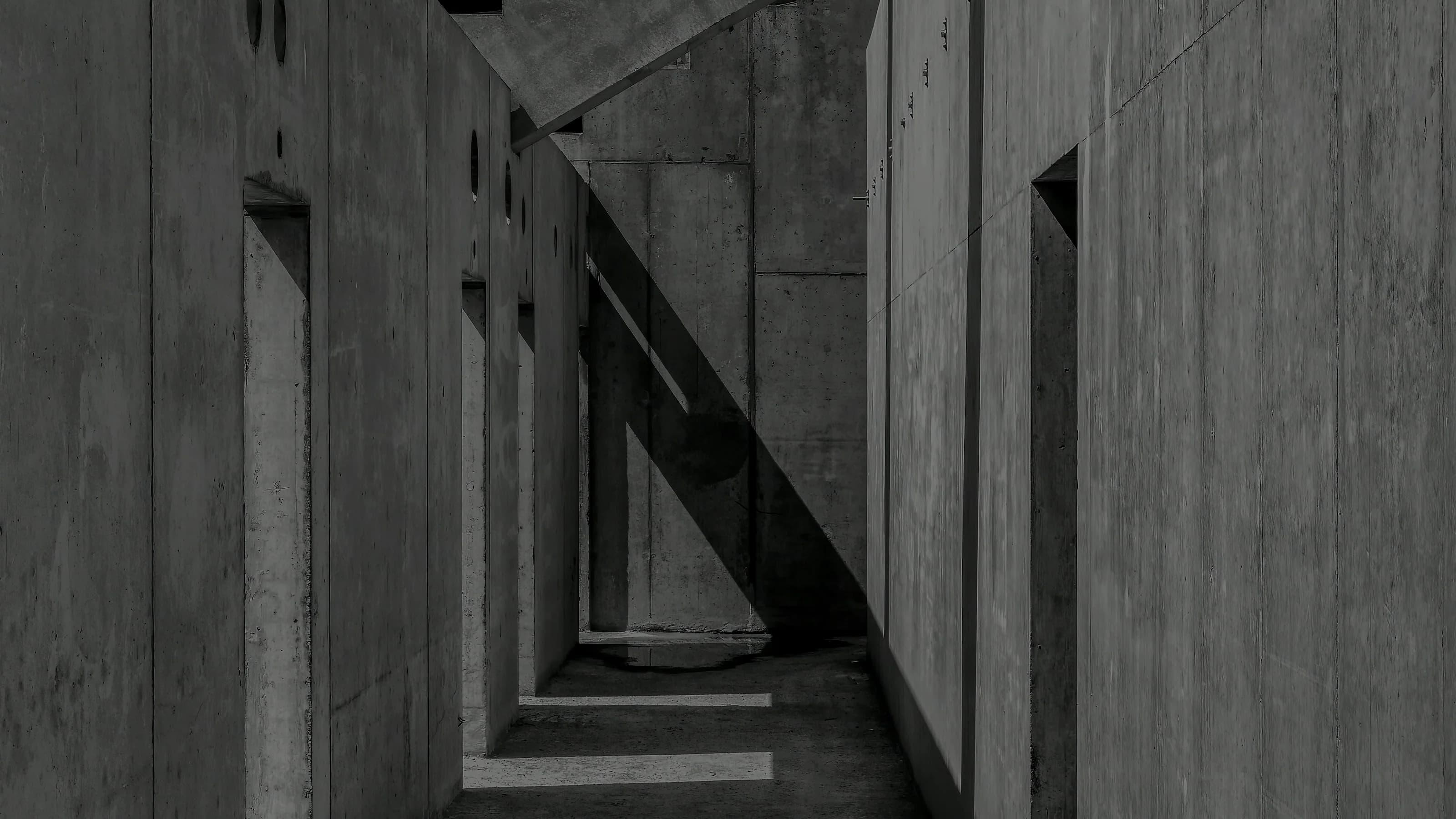 A curved concrete soffit over a top-lit corridor